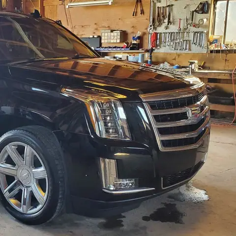 Black Cadillac Escalade detailed in a garage