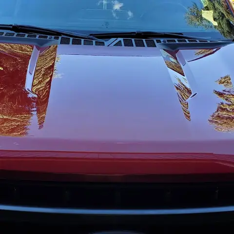 Close-up of the glossy red hood of a Ford F-150 after detailing
