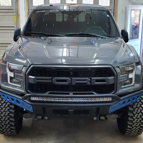 Gray Ford Raptor pickup with blue accents after detailing