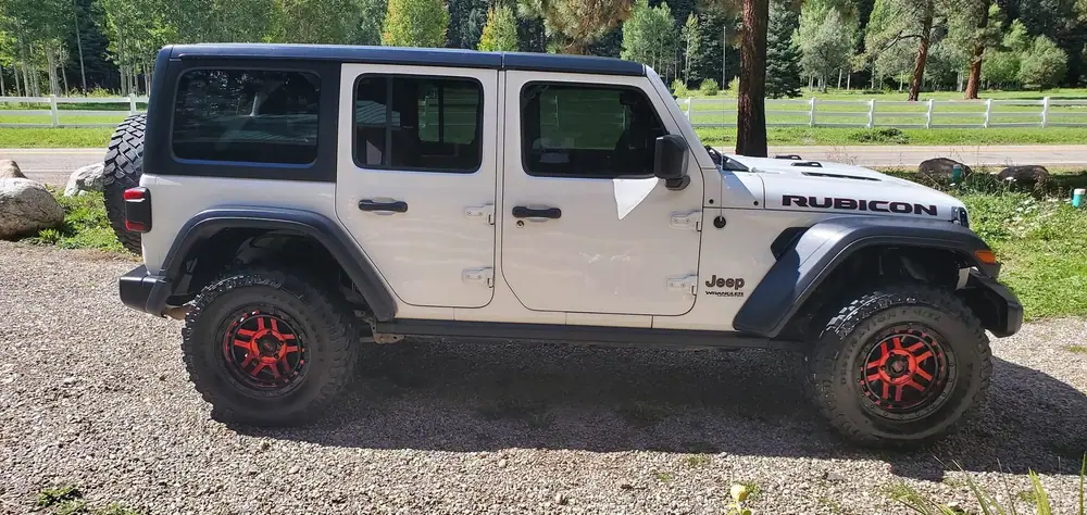 White Jeep Wrangler Rubicon detailed on a gravel drive