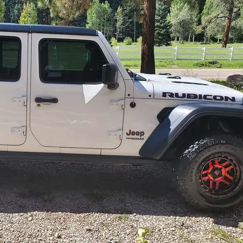 White Jeep Wrangler Rubicon detailed on a gravel drive