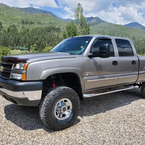 Silver lifted Chevy Silverado HD detailed in a mountain meadow